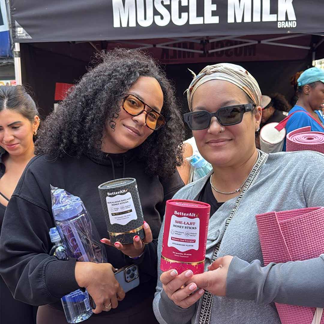 Two people holding BetterAlt products at an outdoor event.