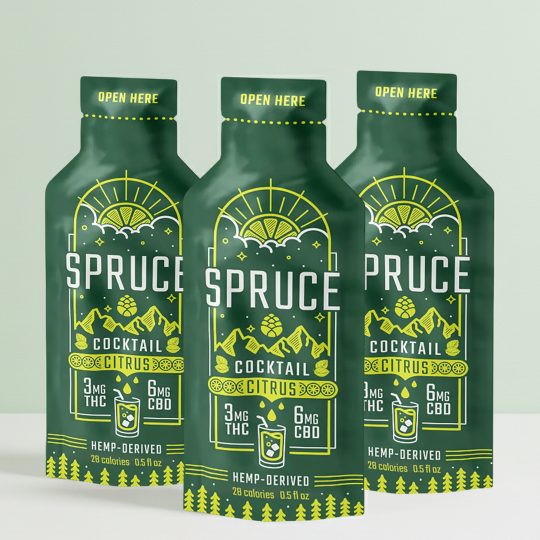 Three green Spruce citrus cocktail pouches with bright yellow graphics.