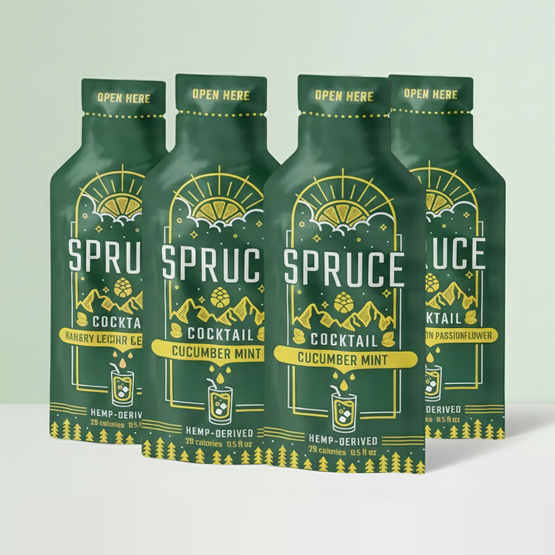 Four green Spruce cocktail packets with mountain imagery.