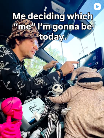 A person in a car with Nightmare Before Christmas dolls and a pink skeleton.