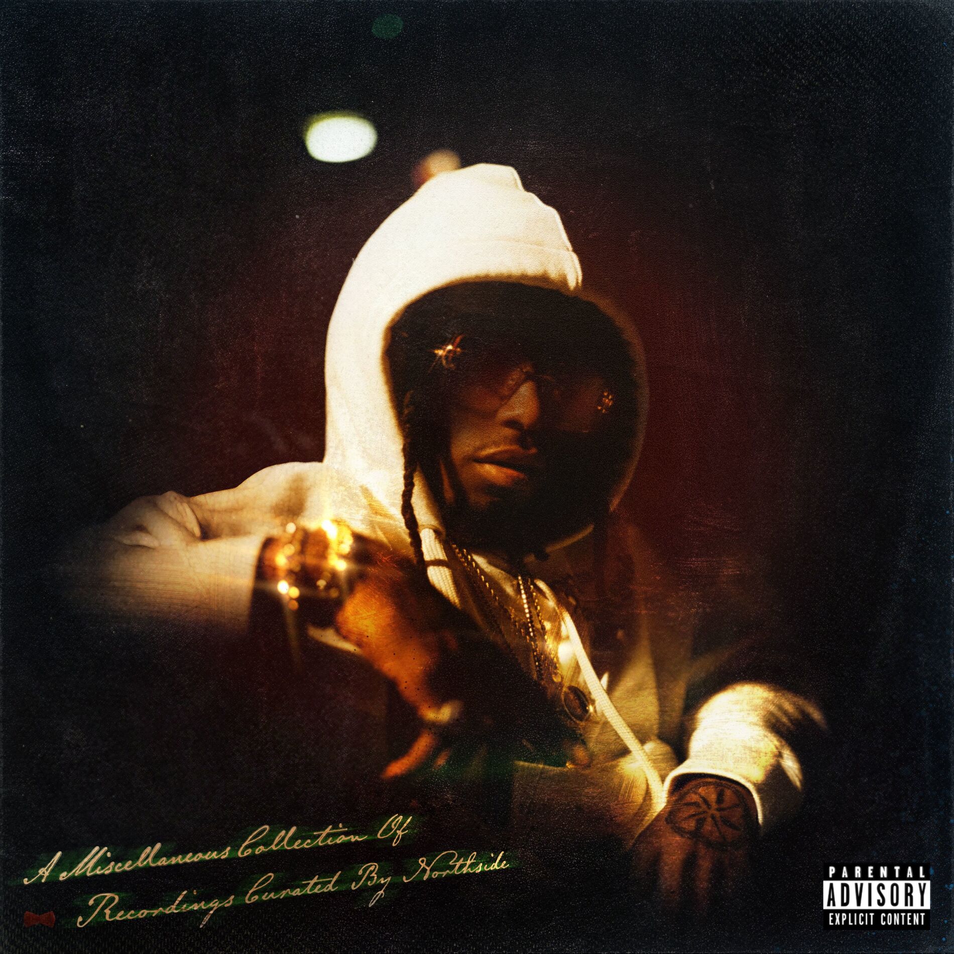 Person in a hoodie and sunglasses, with text and a parental advisory label.