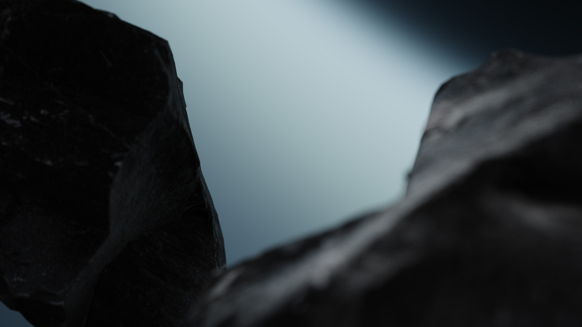 Close-up of dark, textured rocks against a blurred light background.