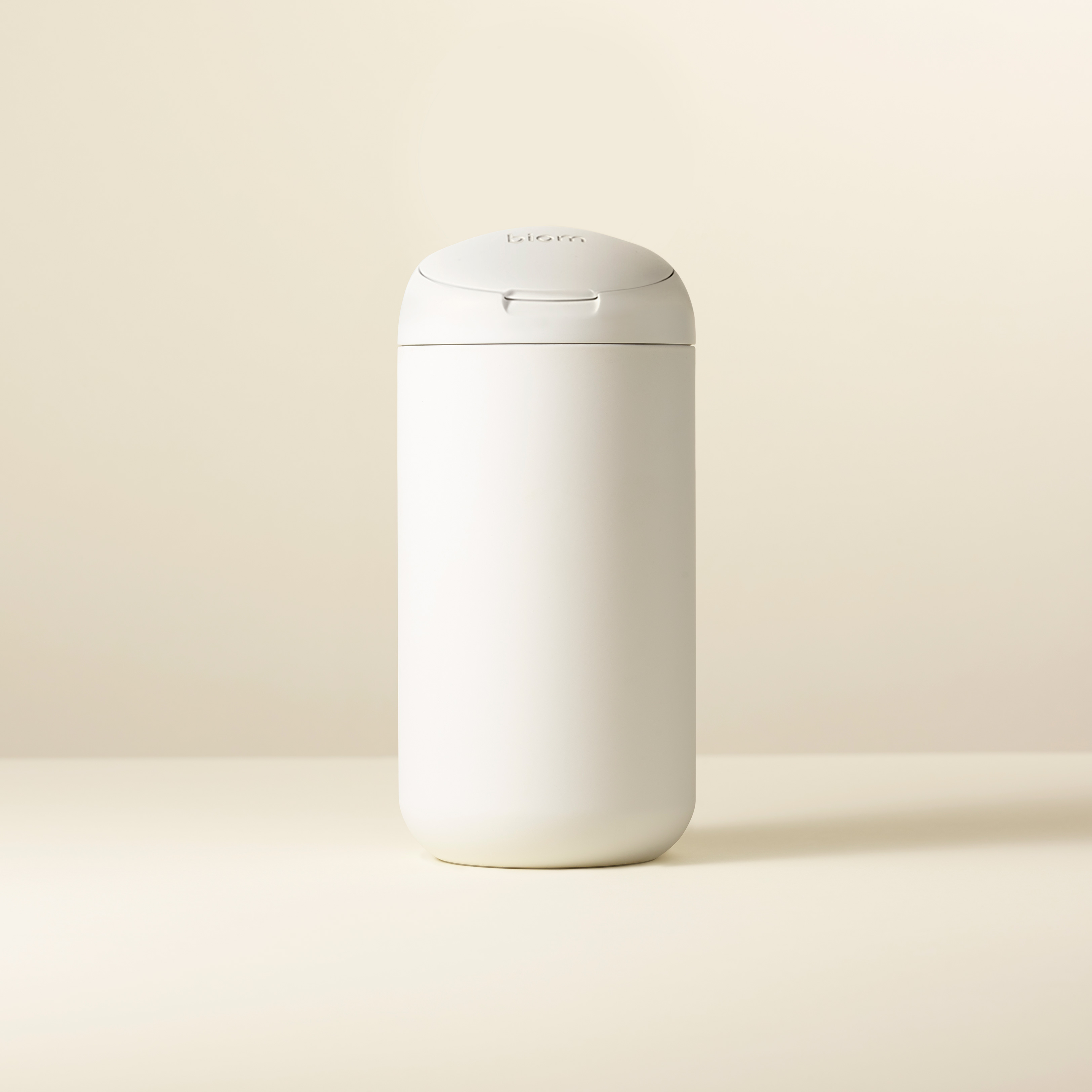 White cylindrical container with a lid on a neutral background.