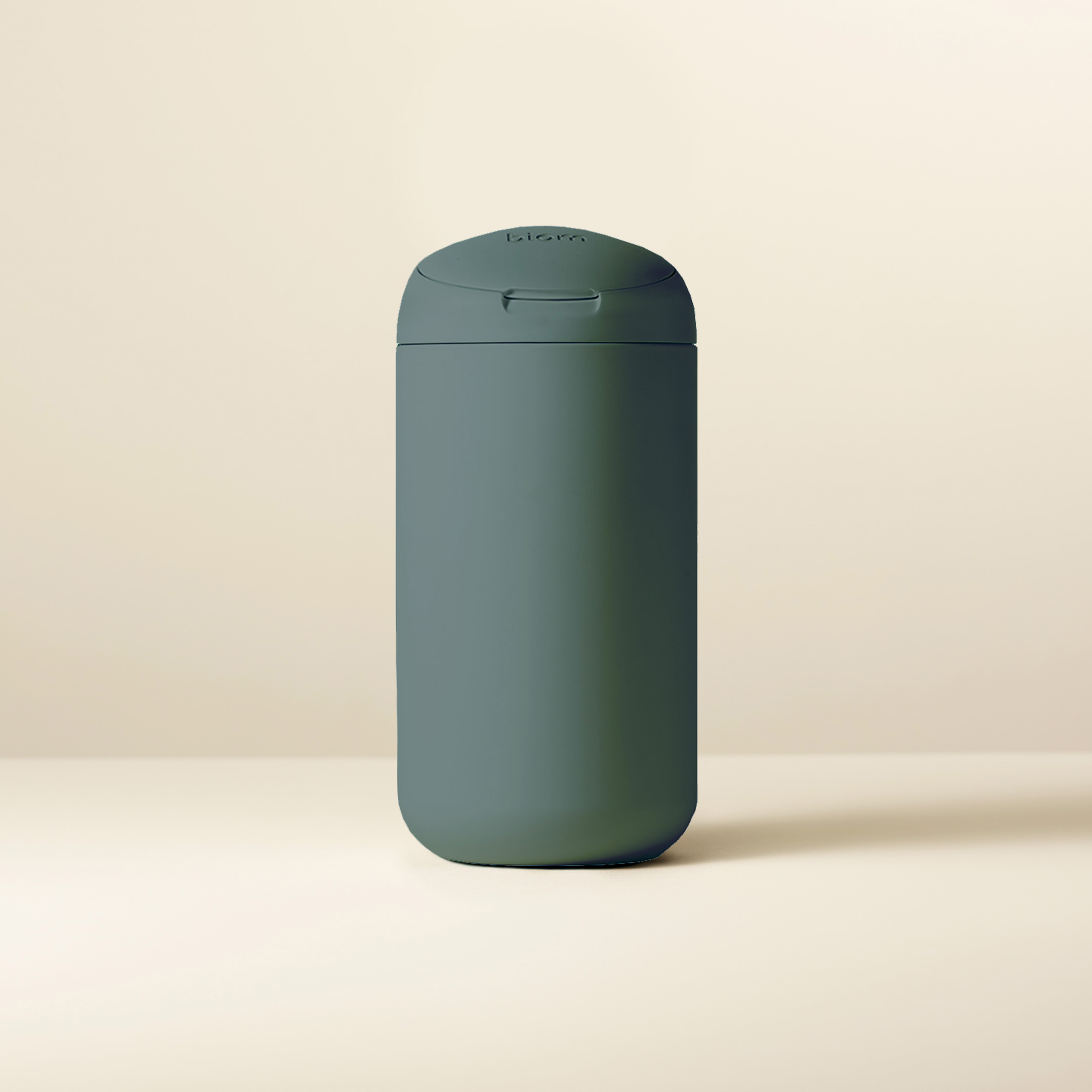 A dark green cylindrical container on a light background.