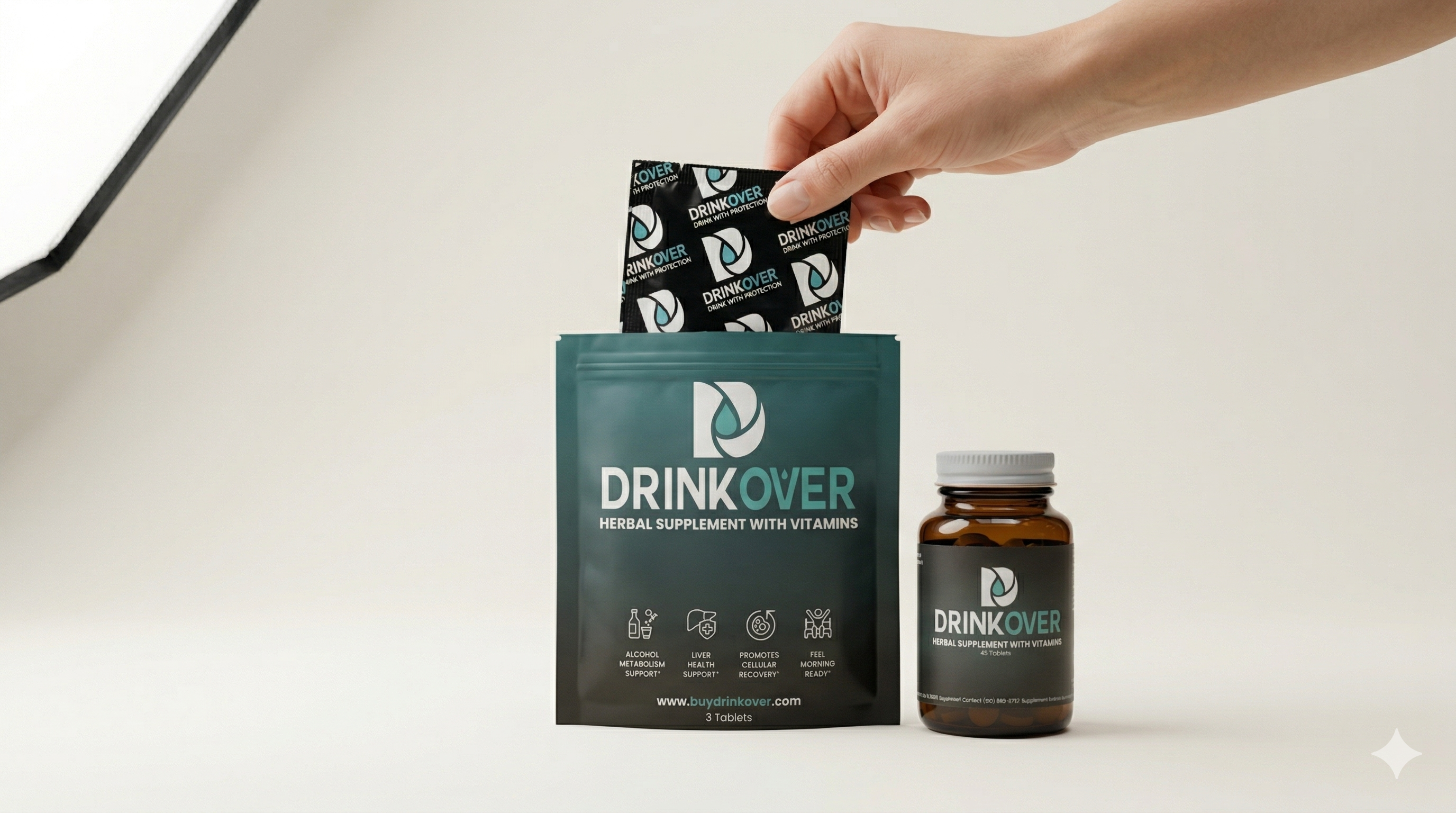 A hand places a Drinkover herbal supplement packet into a larger pouch next to a bottle of the supplement.