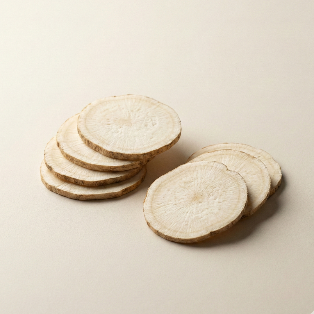 Two small stacks of thinly sliced white root vegetable on a plain background.