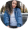A person in a blue jacket smiling outdoors.