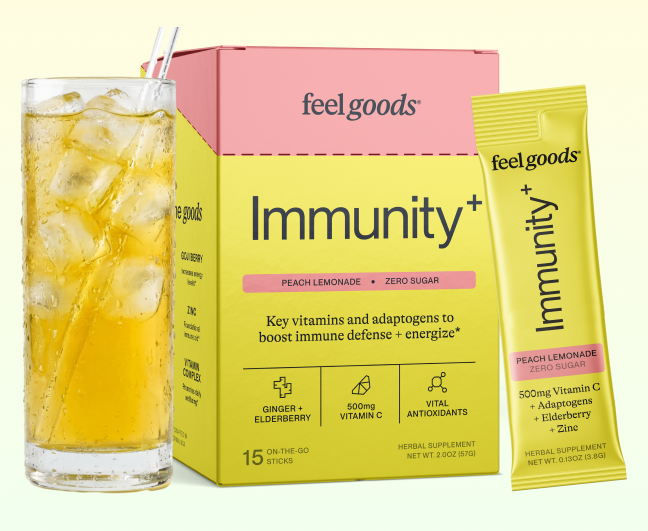 A glass of iced peach lemonade next to a box and packet of Feel Goods Immunity+ drink mix.