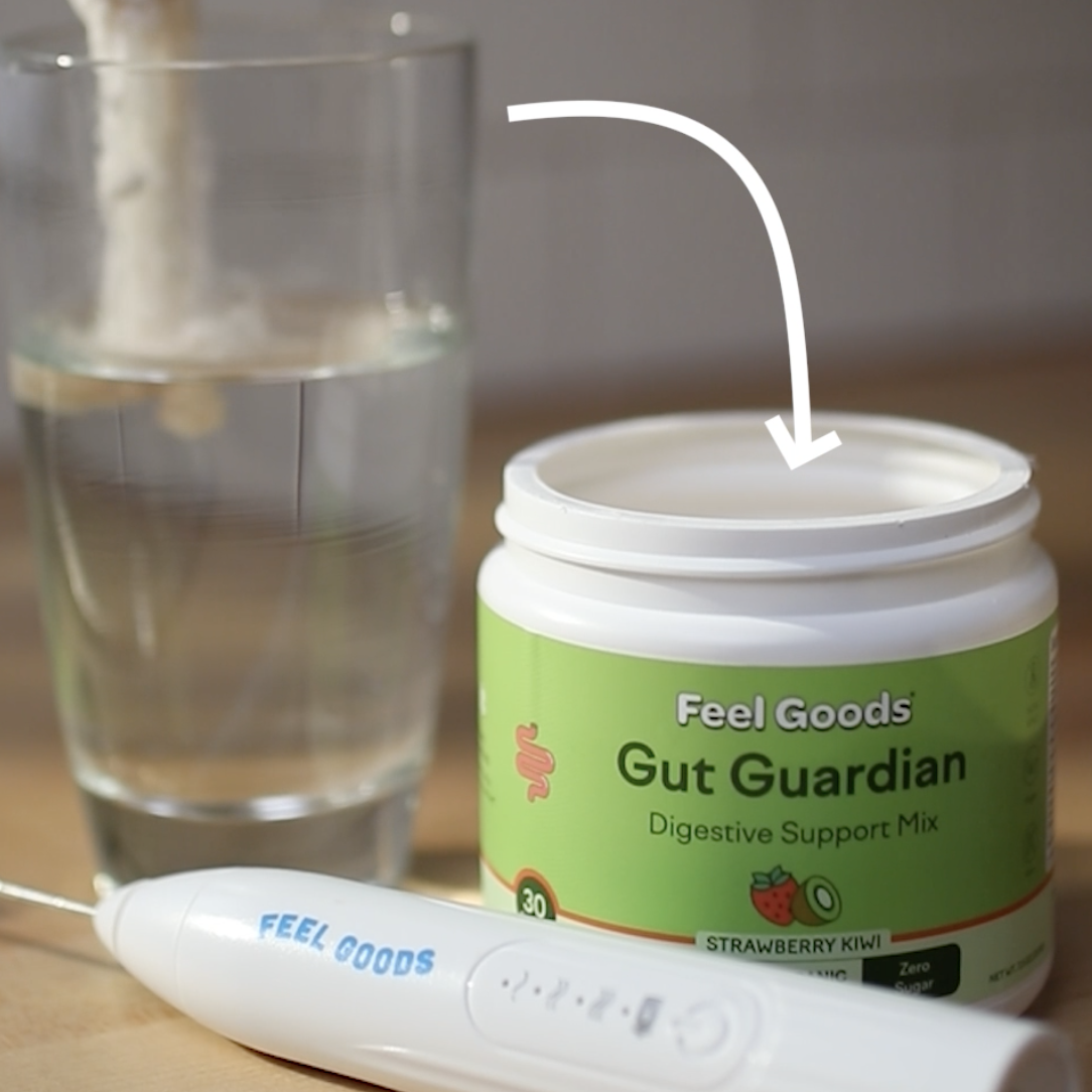 Container of Gut Guardian mix, glass of water, and a mixing tool on a table.