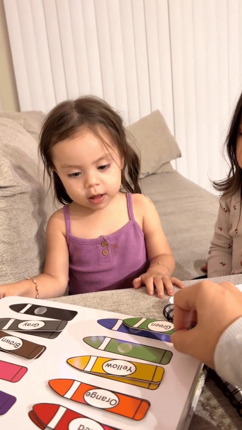 Child using an educational color-matching activity book
