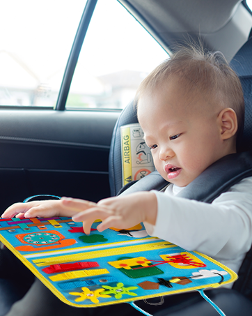 Baby in car seat playing with colorful activity board.