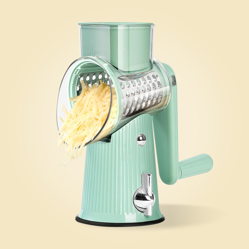 Manual rotary cheese grater with shredded cheese, on a light background.