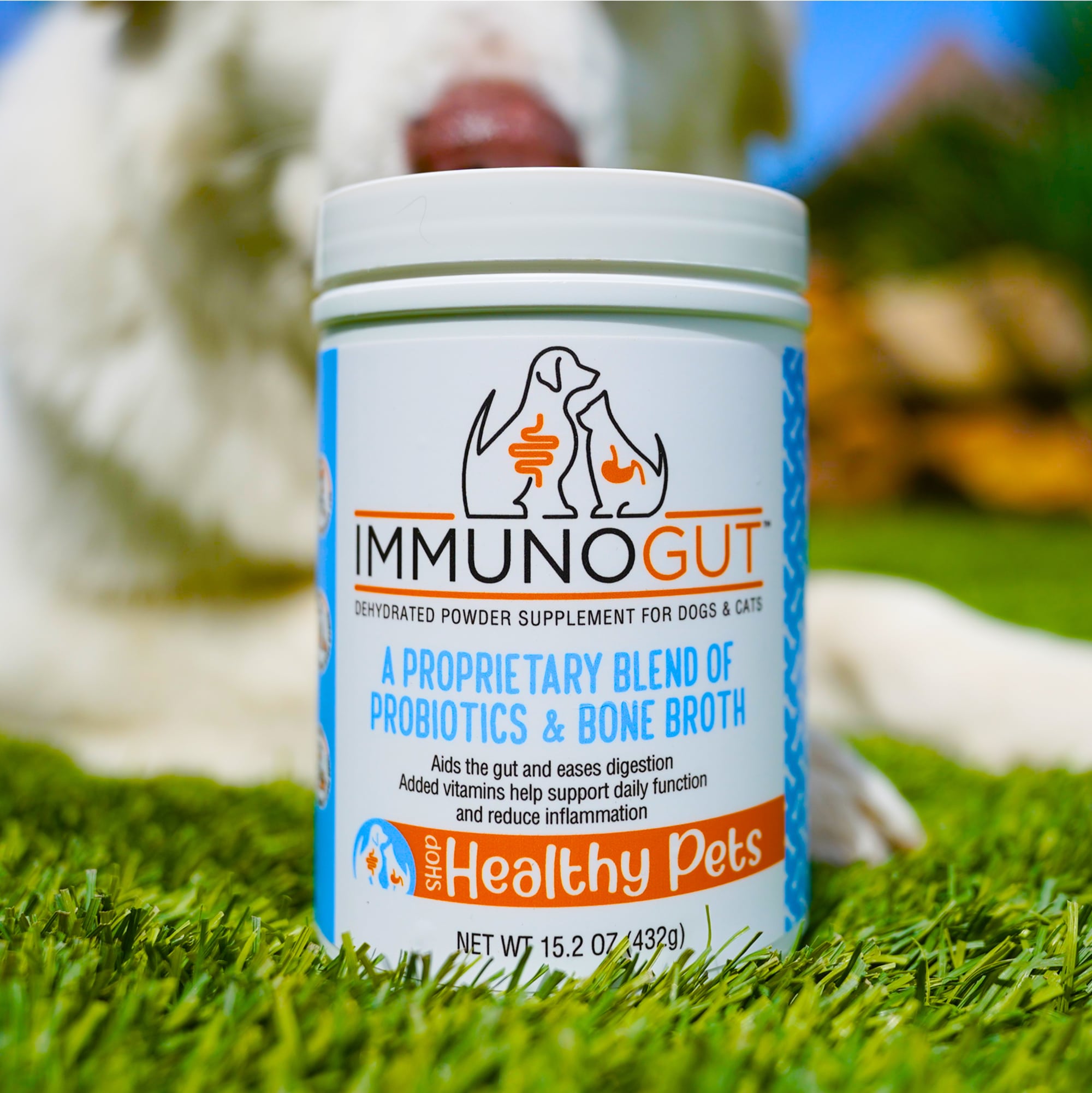 Container of pet supplement on grass with a dog in the background.