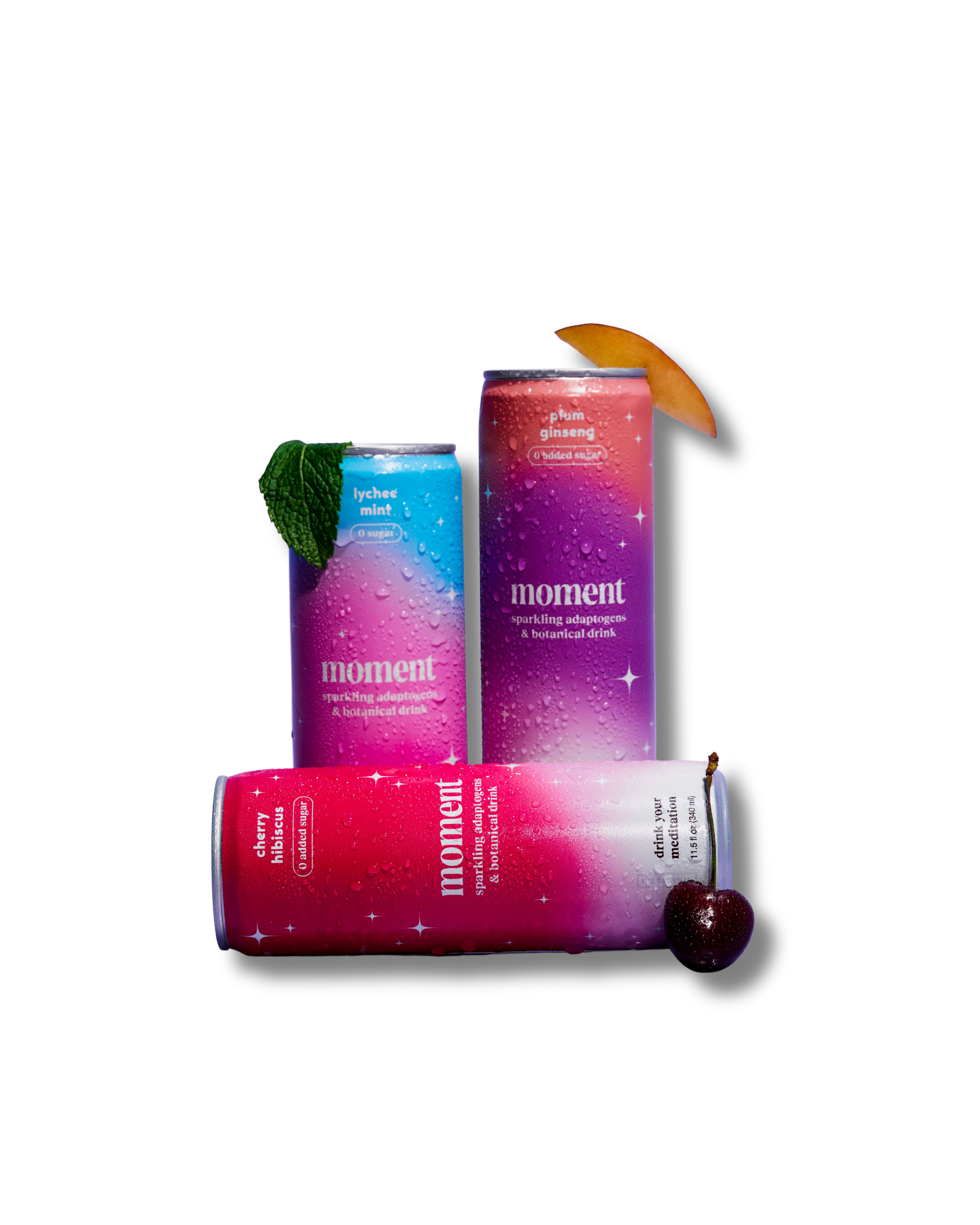 Three colorful beverage cans with fruit garnish on a plain background.