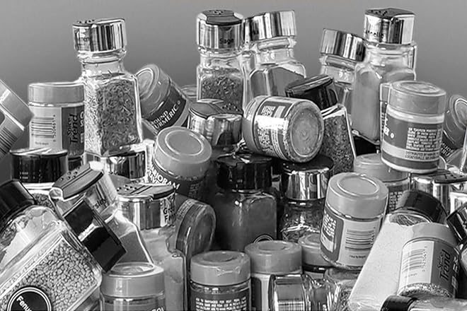 Spice jars piled up in a cabinet