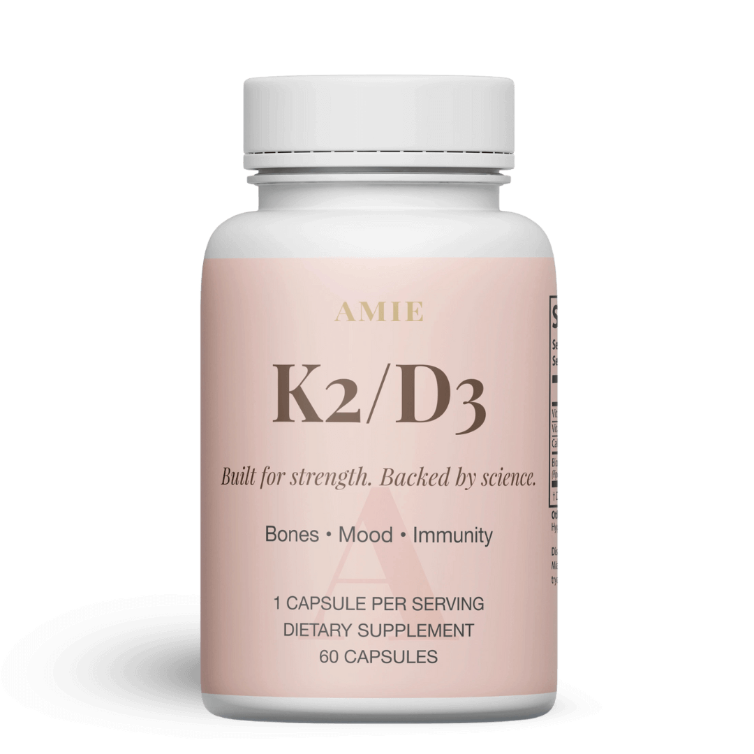 Bottle of K2/D3 dietary supplement capsules with pink label.