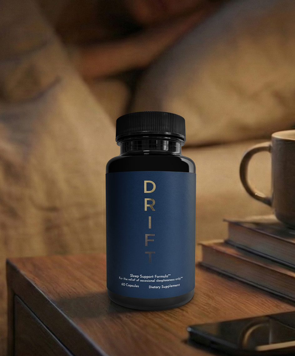 A bottle of Drift sleep supplement on a nightstand next to a bed with a person sleeping.