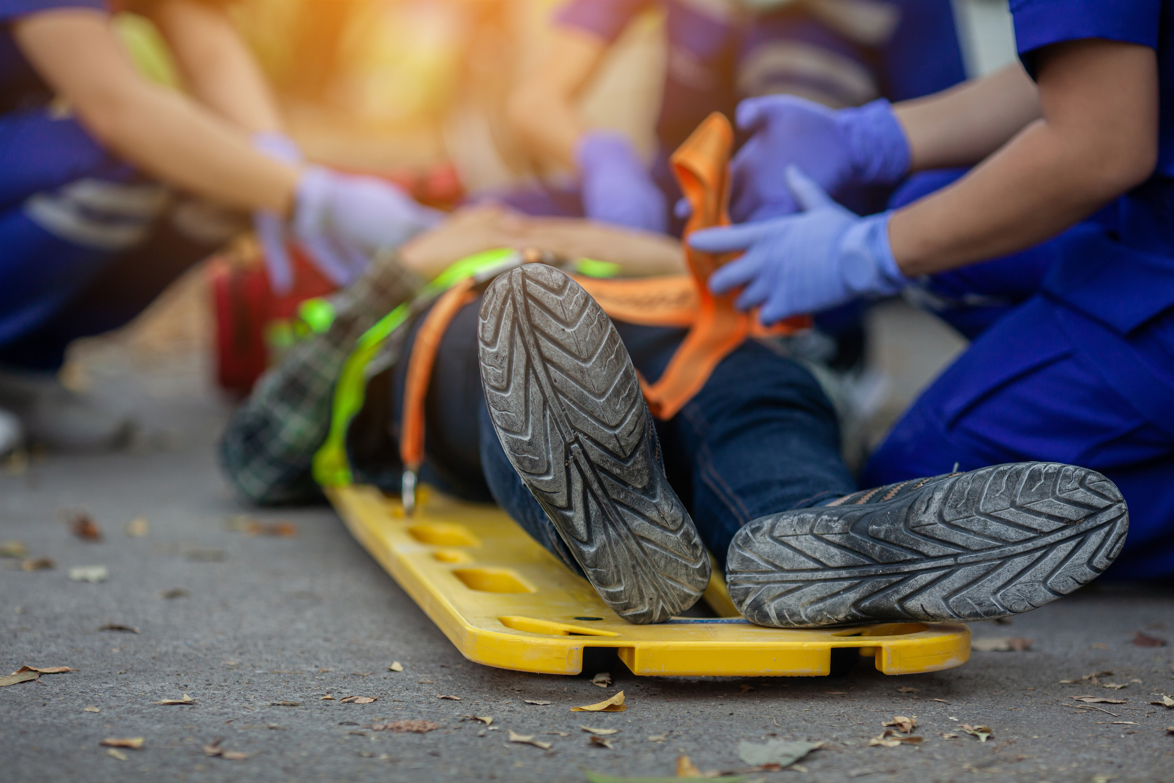 Emergency responders securing a person on a stretcher with a neck brace.