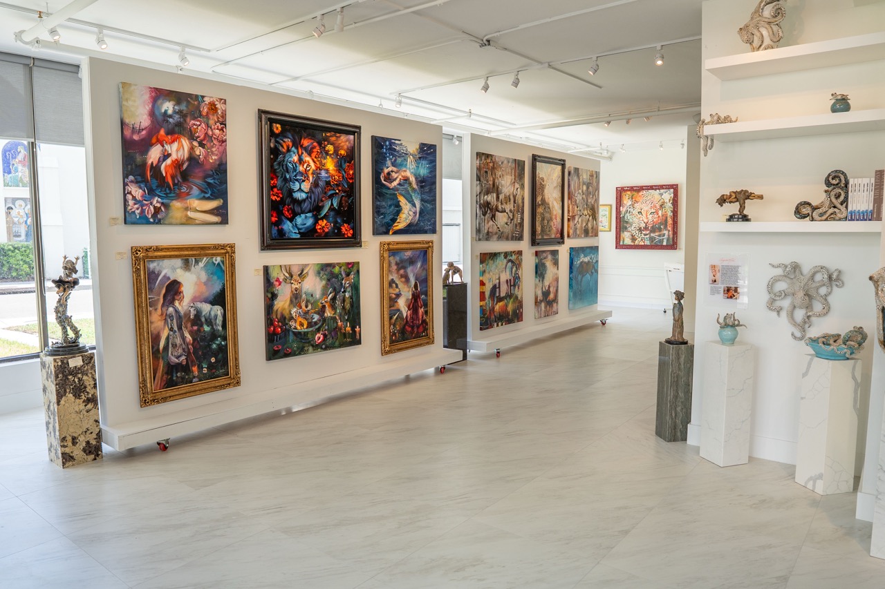 Wall filled with various colorful art pieces in a gallery.