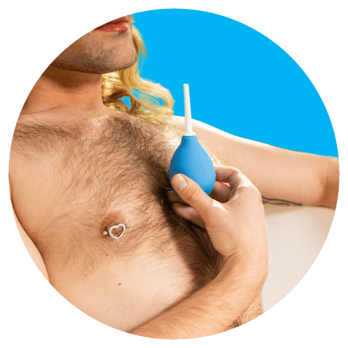 Person with chest hair holding a blue bulb syringe against a blue background.