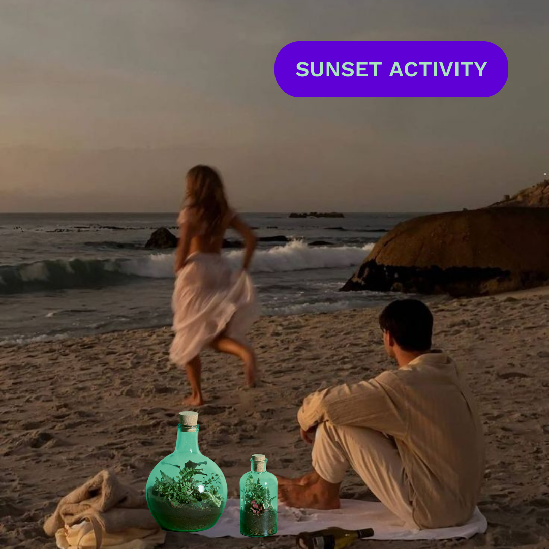 A person sitting on a beach at sunset, another running, with decorative bottles in the foreground.