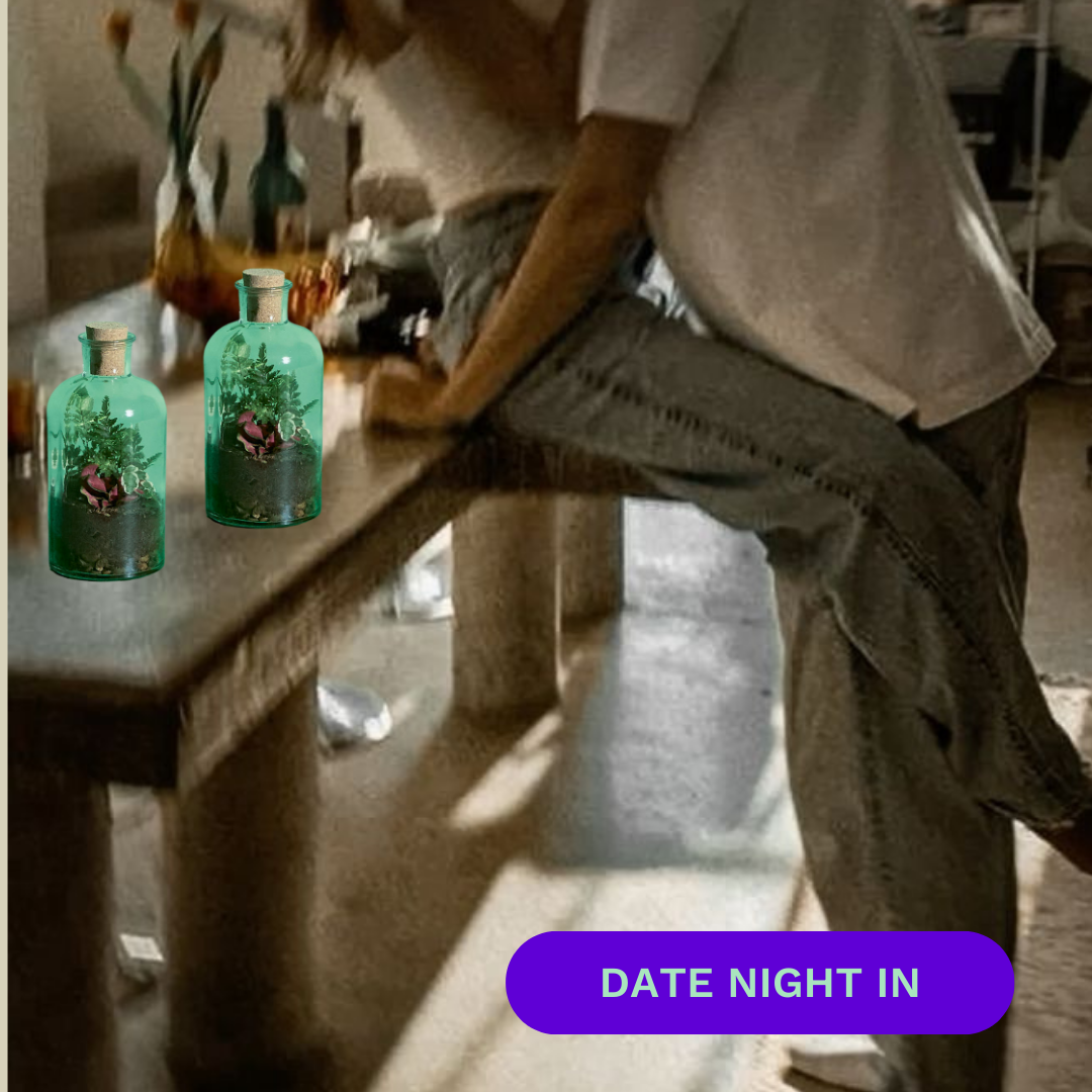 Two people embracing on a table with decorative bottles and 'Date Night In' text.