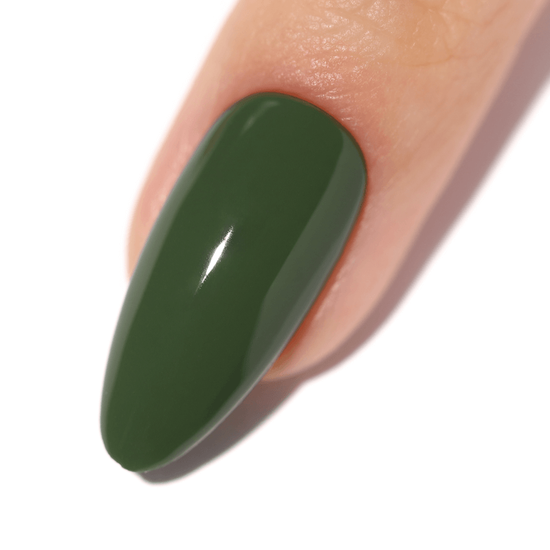 Close-up of a fingernail painted in glossy dark green polish.