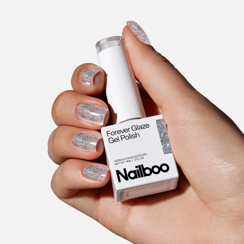 Hand holding a bottle of Nailboo Forever Glaze Gel Polish with glittery nails.