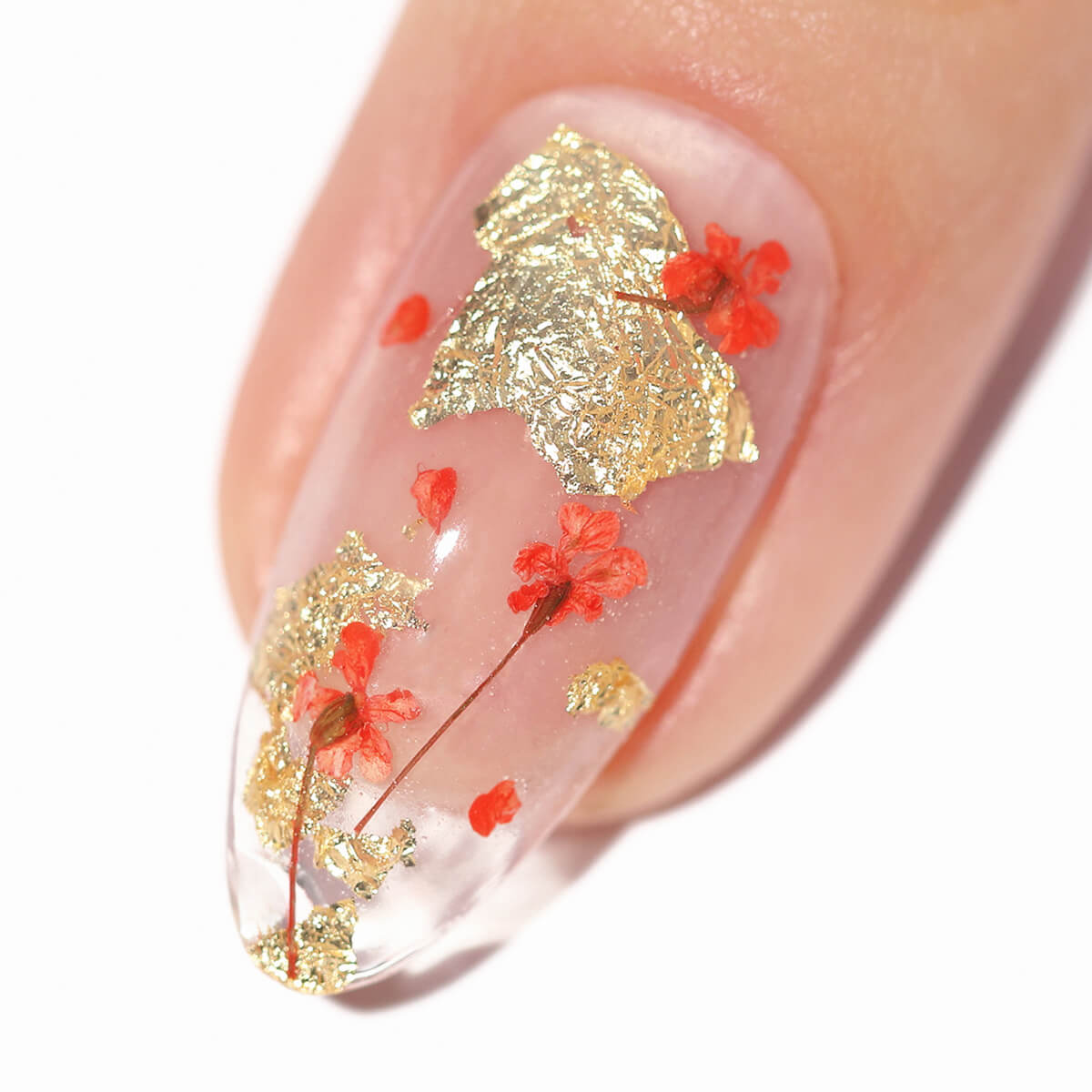 Nail with gold foil and small red flowers design.