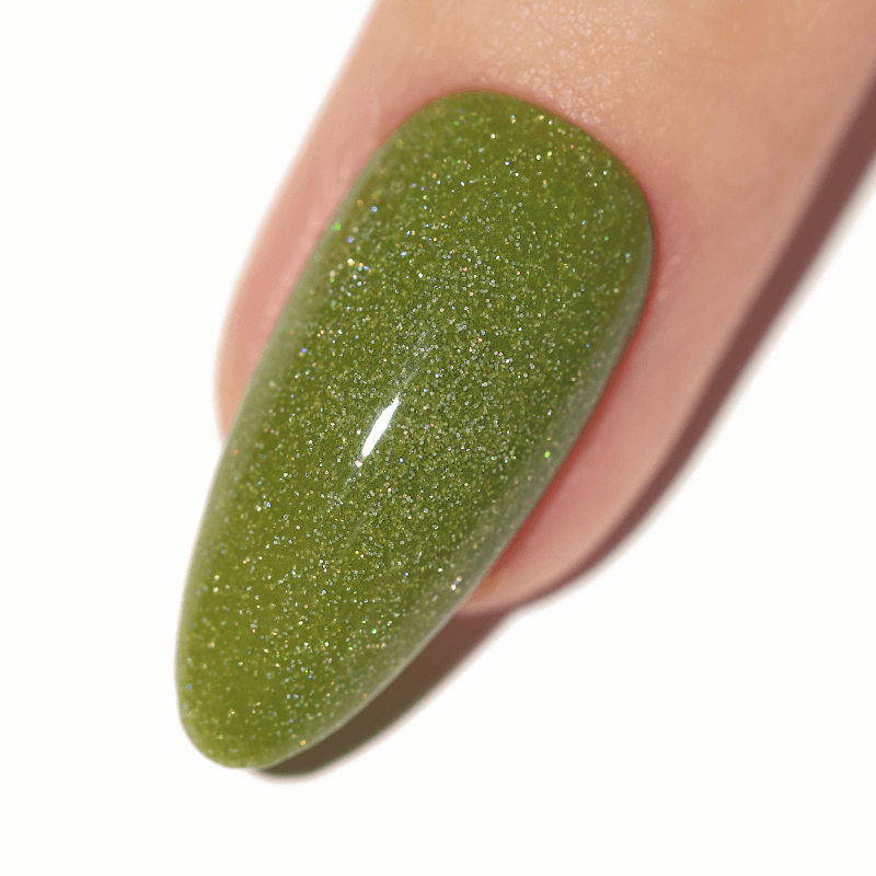 Close-up of a fingernail with green glittery nail polish.