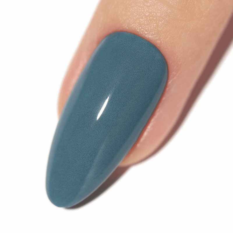 Close-up of a fingernail painted in teal polish.