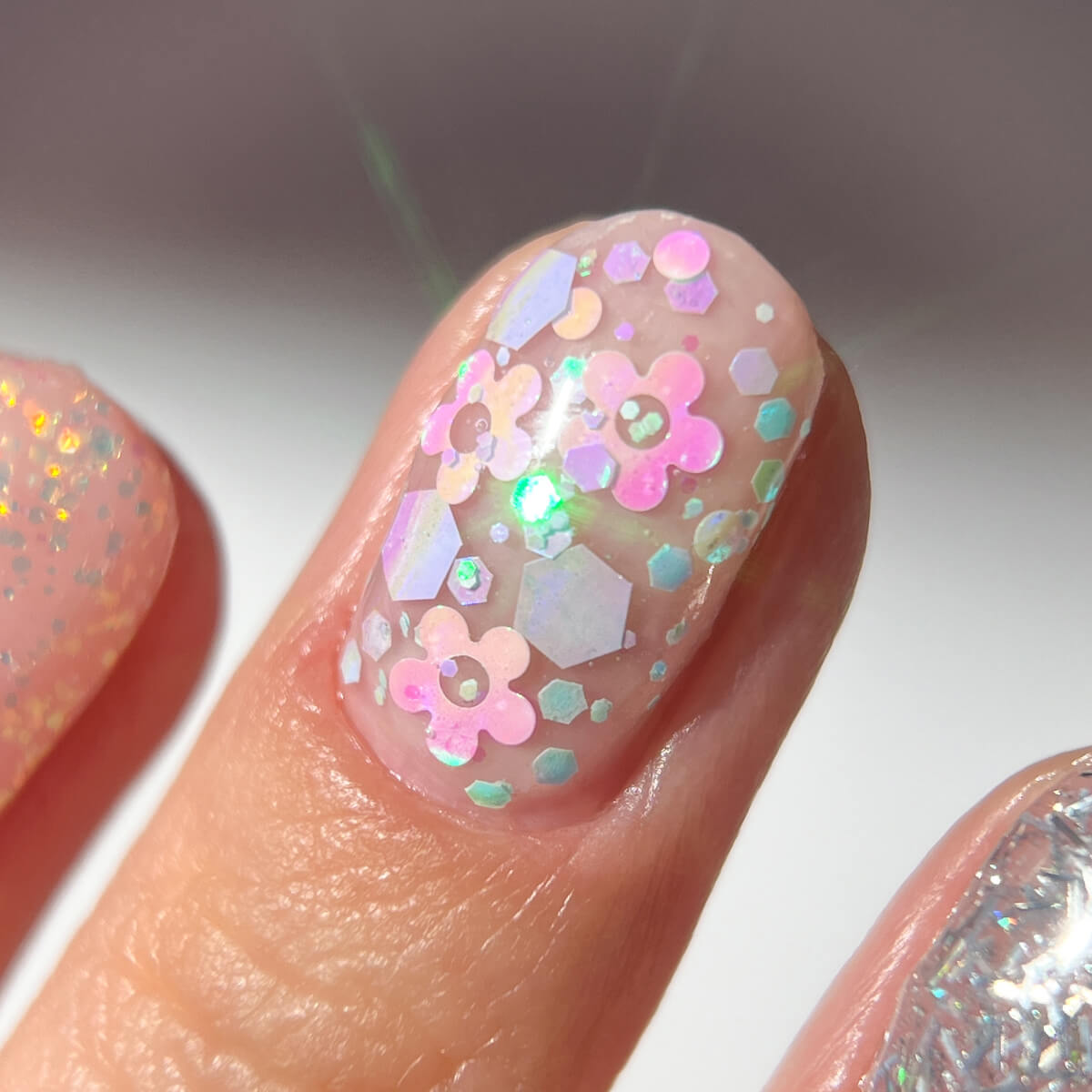 Close-up of a fingernail with colorful floral nail art.