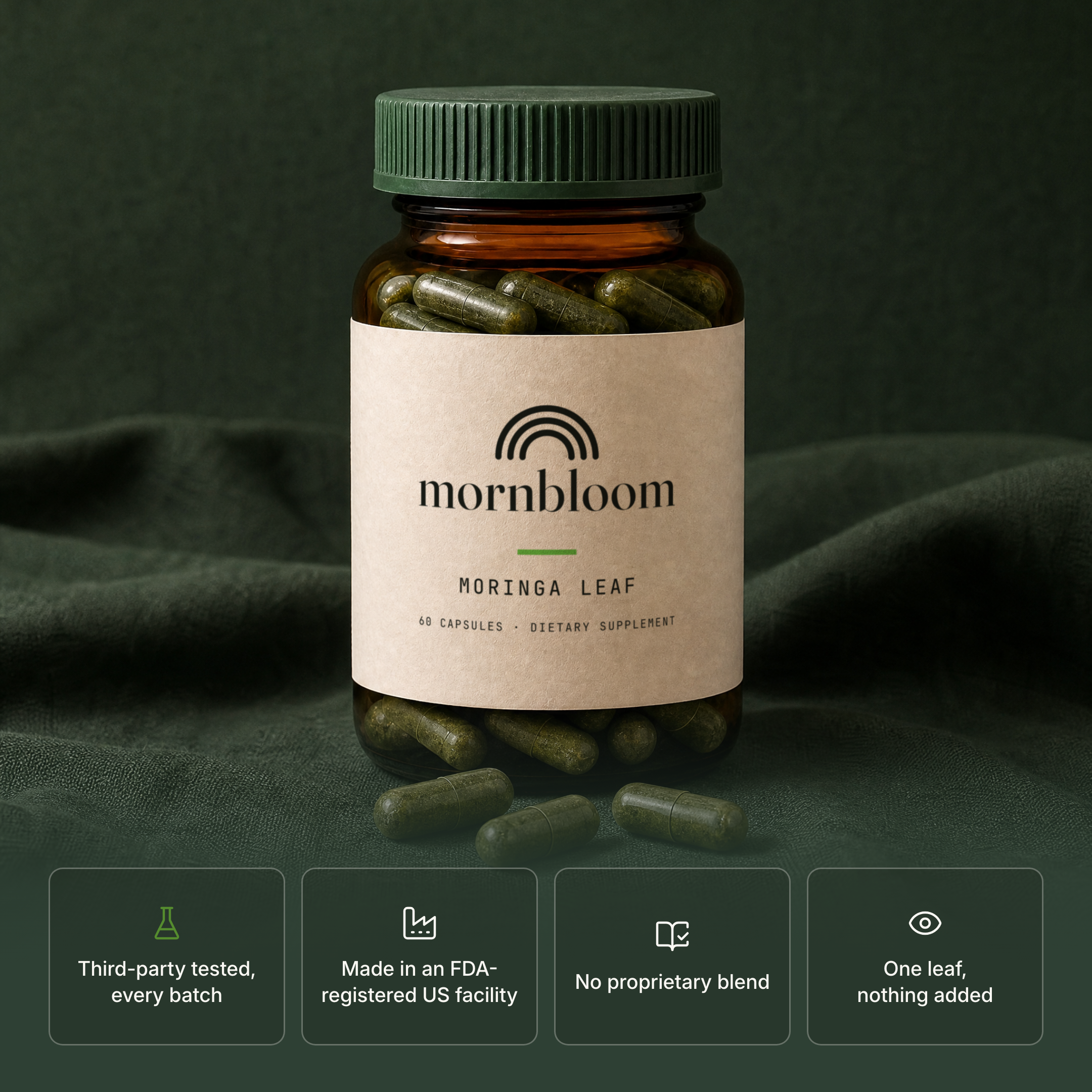 A bottle of mornbloom Moringa Leaf supplement capsules on a dark green fabric background.