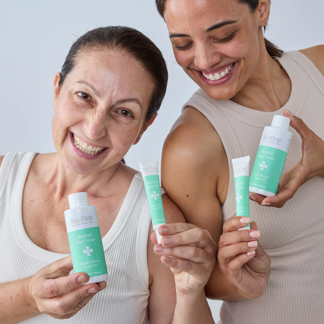 Two women smiling while holding Bio-First skincare products.