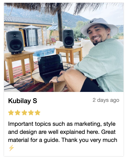 Man smiling by a pool with speakers and a laptop nearby.