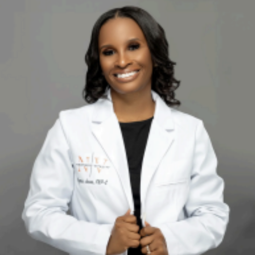 Person smiling in a white lab coat against a gray background.