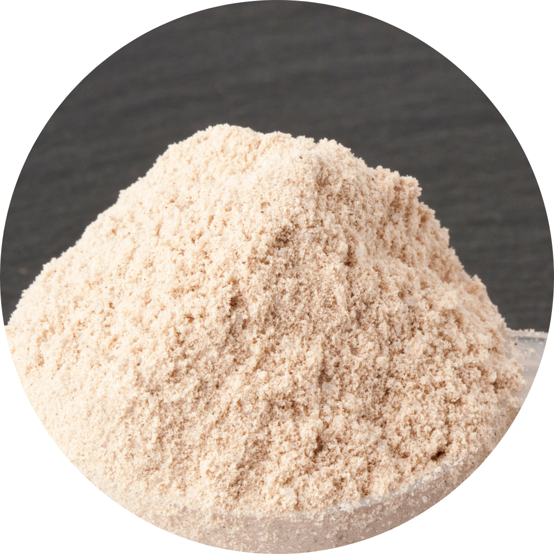 A mound of light brown powder on a dark surface.