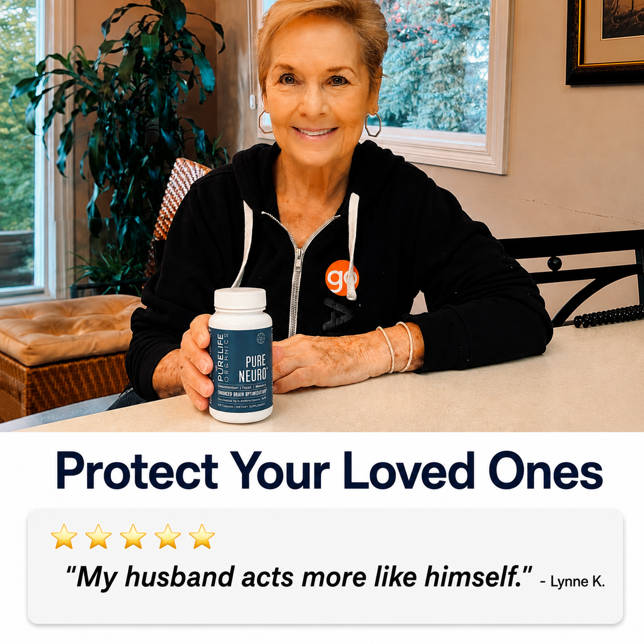 A smiling older woman in a black hoodie holds a white bottle of Purelife Organics supplements.