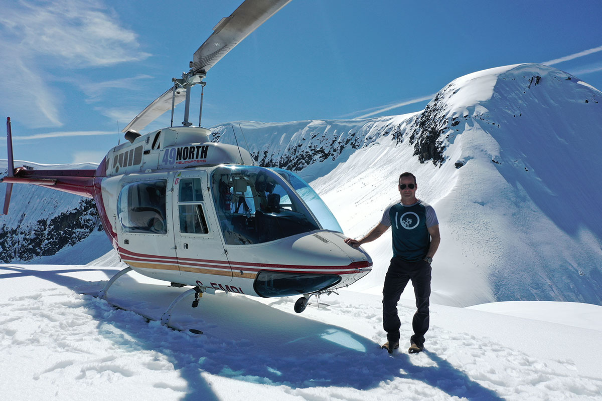 Todd next to a helicopter in the glacier mountains