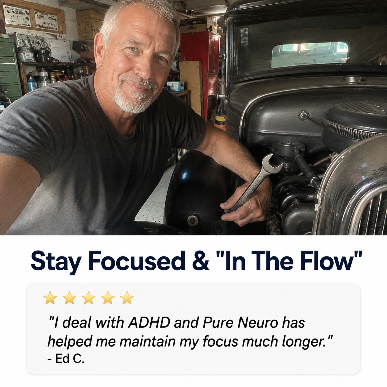 A man holding a wrench smiles while working on the engine of a classic car in a garage.