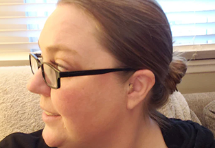Side profile of a person wearing glasses sitting on a couch.
