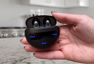 Hand holding open black wireless earbuds case with blue LED lights.