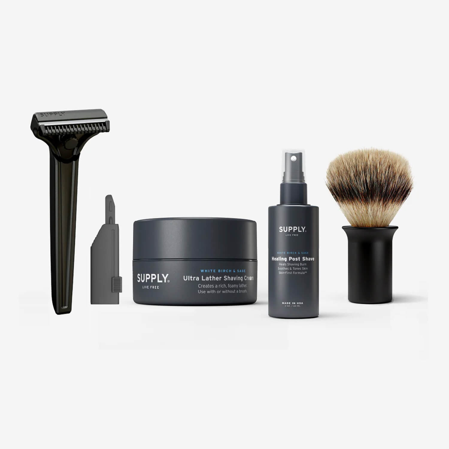 Shaving kit with razor, blades, shaving cream, post-shave spray, and brush on a white background.