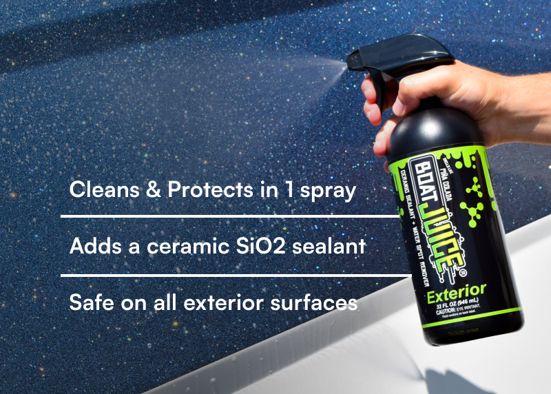 A person's hand spraying Boat Juice Exterior cleaner onto a sparkly dark blue surface.