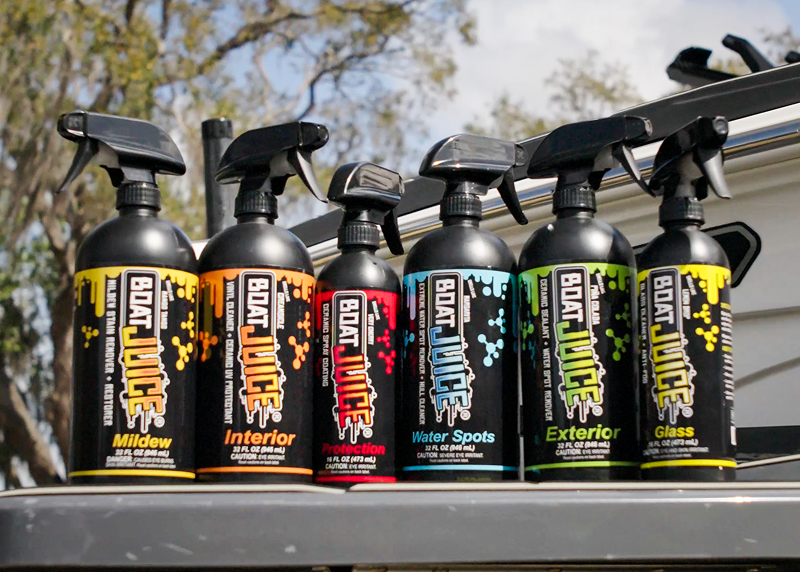 A lineup of six different Boat Juice brand boat cleaning products in spray bottles.