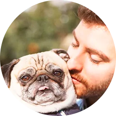 Man lovingly holding a pug.