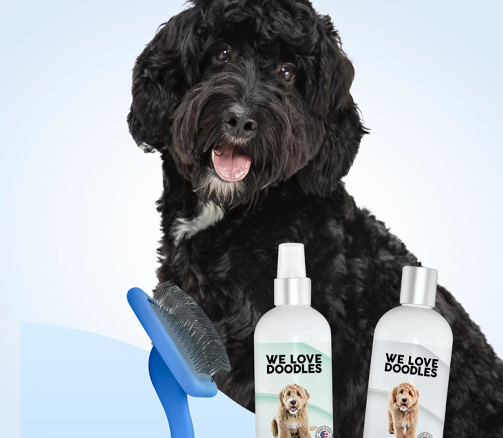 Black dog with grooming brush and two bottles labeled 'We Love Doodles.'