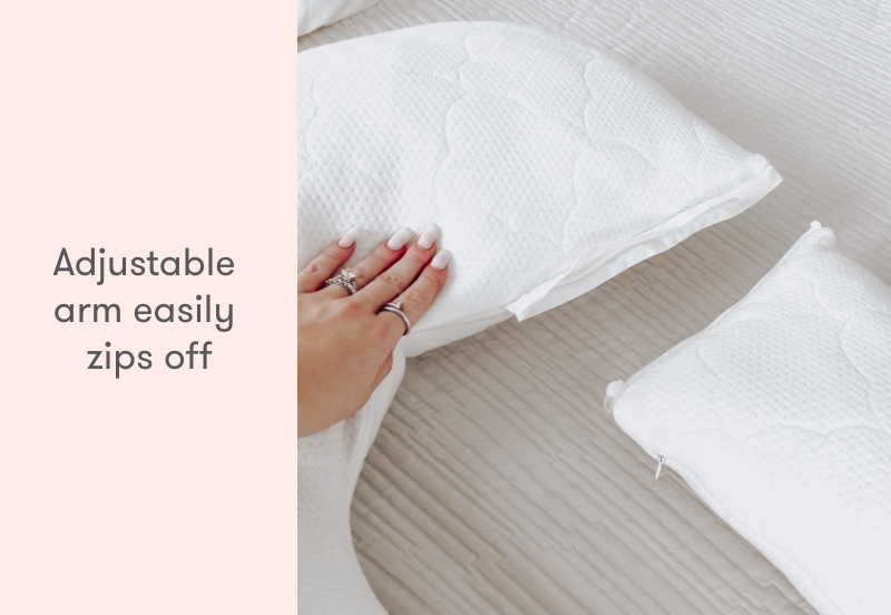 Hand showing how The Newton Pillow's arm is adjustable and can easily zip off