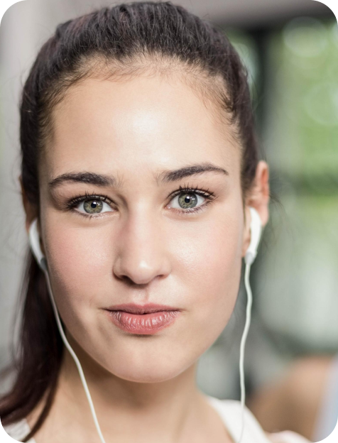 Person with dark hair wearing earphones, close-up.