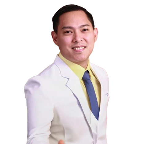 Person in a white suit with a yellow shirt and blue tie, smiling.